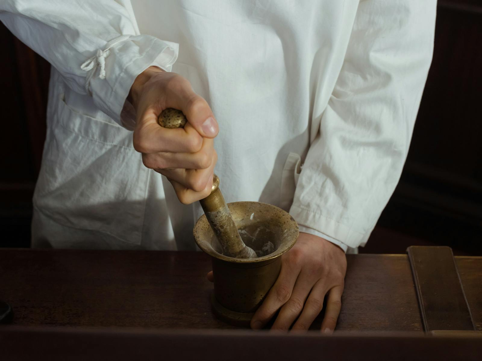 Compounding pharmacist using mortar and pestle